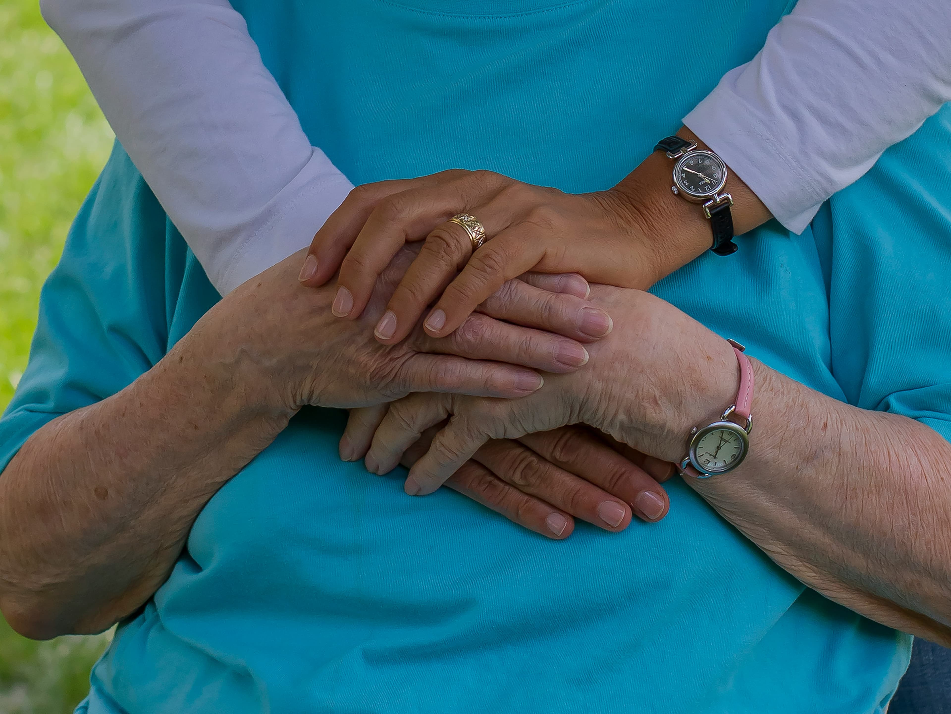 A caregiver holding hands with a senior client, a quiet moment of connection