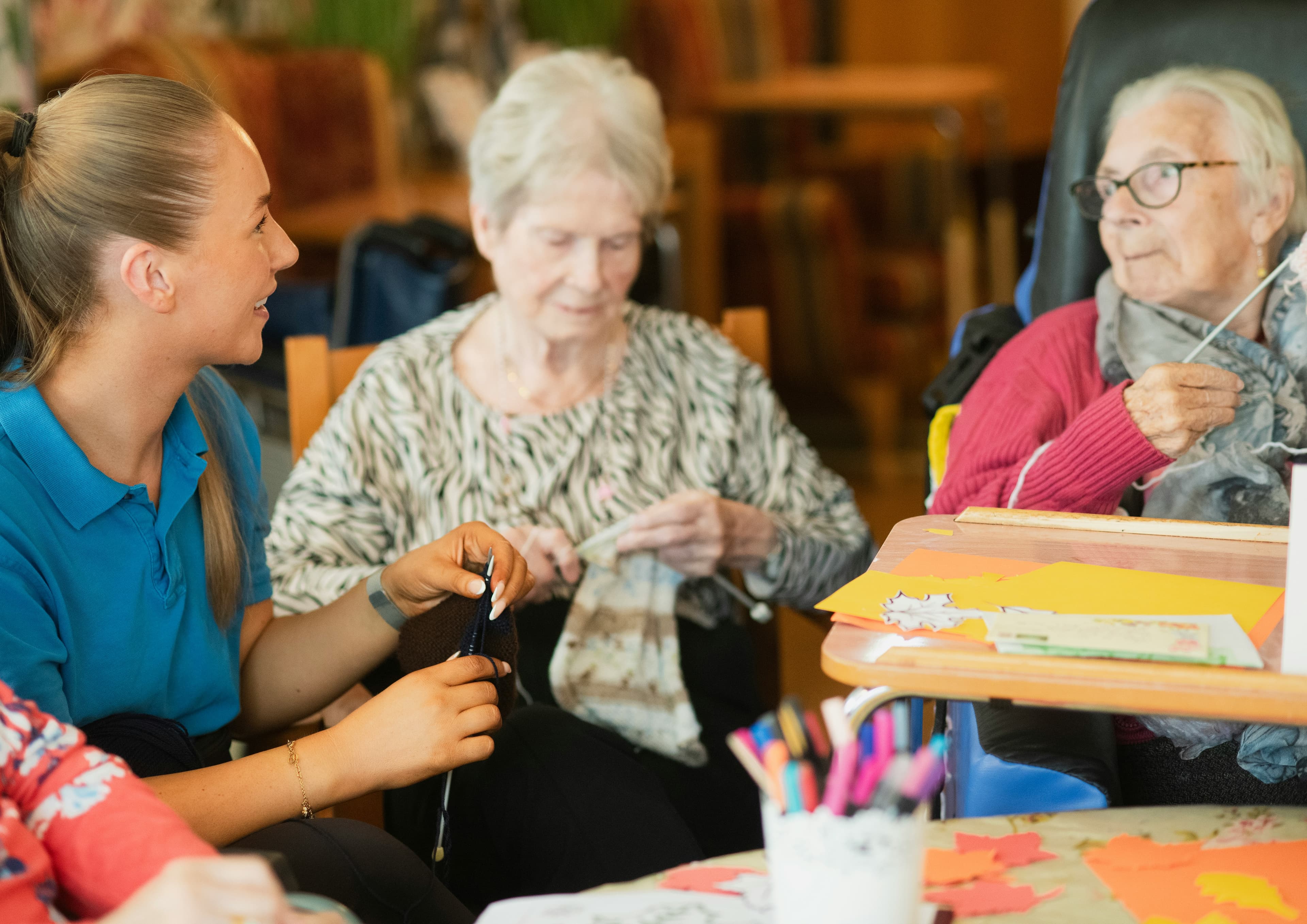 A BrevCare caregiver spending time with clients during a craft activity